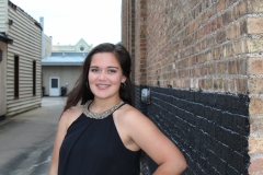 Mia's Senior Photos against the brick siding of Temple Theater alleyway.