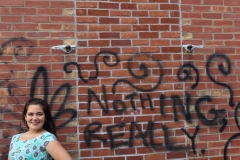 Mia's Senior Photos against a spray-painted wall.